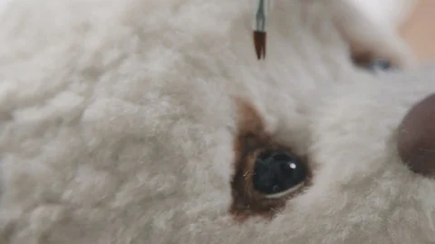 Master paints eyes for a teddy bear in an old-fashioned style Stock Footage
