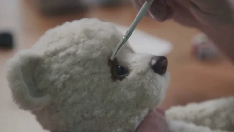 Master paints eyes for a teddy bear in an old-fashioned style Stock Footage
