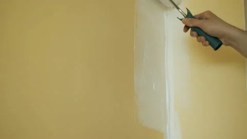 Master paints a wall with a roller in white. Office renovation and renovation Video stock 132792130