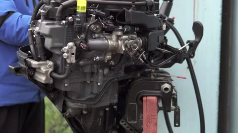 The master performs comprehensive diagnostics and repairs of the outboard motor. Stock Footage 265864815