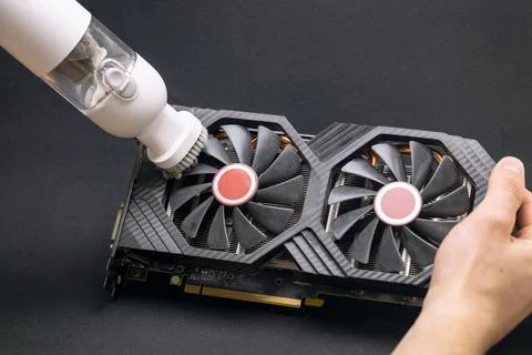 The master performs maintenance of a modern video card, cleaning the video ca Stock Photos
