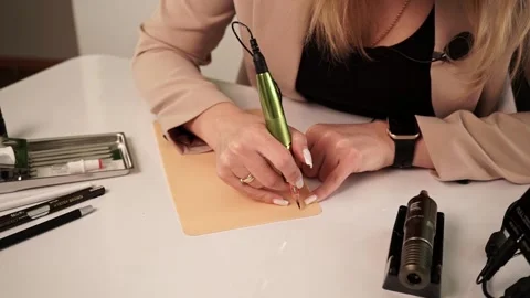 Master in permanent make-up sitting at the table works, learns permanent make-up Stock Footage 188750484