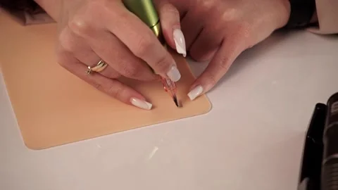 Master in permanent make-up sitting at the table works, learns permanent make-up Stock Footage 188750505