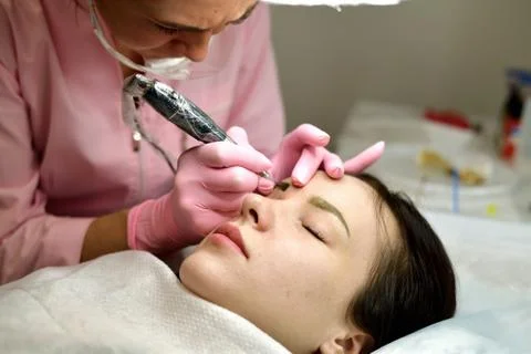 Master of permanent tattoo at work Stock Photos
