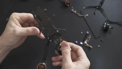 Master picks up the frame of a broken FPV drone Stock Footage 149774176