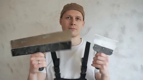 Master plasterer shows the spatulas to the camera with a desire to get to work Stock Footage 144656898