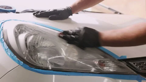 The master polishes the headlights of a white car in a car box Stock Footage 209124508