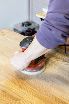 Master polishes table using polishing machine Stock Photos