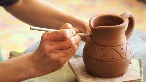 Master potter draw a pattern on a clay pot Stock Footage 235758923
