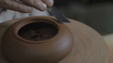 The master potter processes the teapot from Yixing clay with a metal spatula Stock Footage 119000278