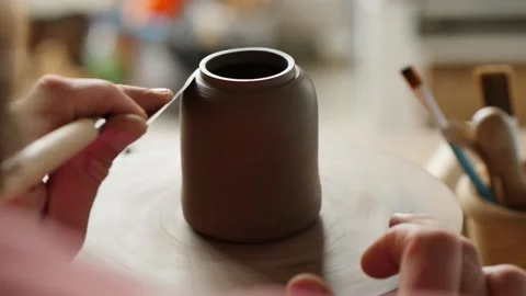 Master potter shapes a clay teapot on a potter's wheel using a special tool Stock Footage 145543914