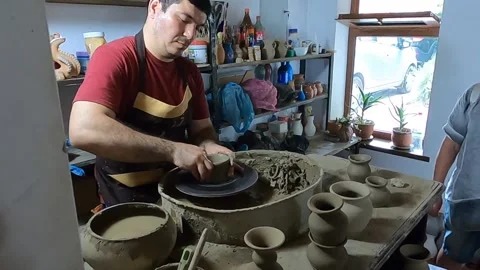 Master potter shaping clay vase on a wheel in Samarkand workshop Stock Footage 336327538