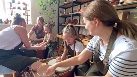 Master potter teaches children and their moms to make a clay jug  Stock Footage 277790127