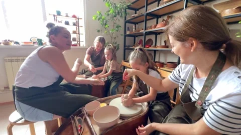 Master potter teaches children and their moms to make a clay jug Stock Footage 277790200
