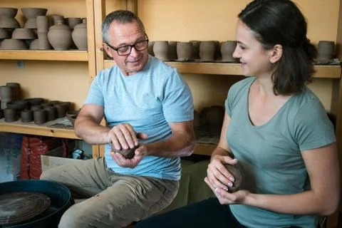 Master potter teaches student in workshop Stock Photos