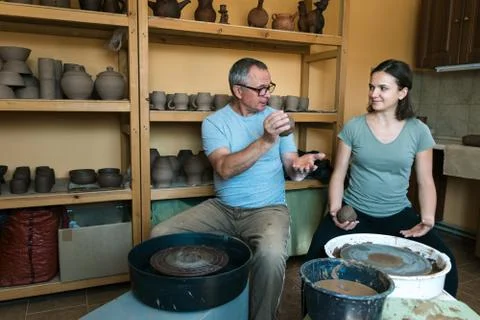 Master potter teaches student in workshop Stock Photos