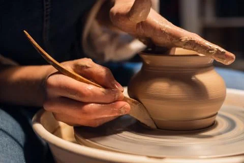 A master in a pottery workshop shows the technique of modeling a pot on a Potter Stock Photos