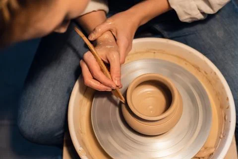 A master in a pottery workshop shows the technique of modeling a pot on a potter Stock Photos