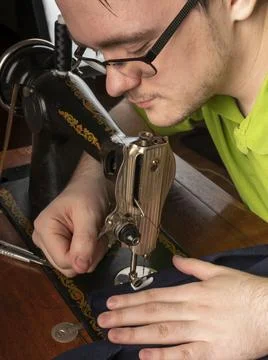 The master prepares the sewing machine for work Preparing for sewing clothes Stock Photos