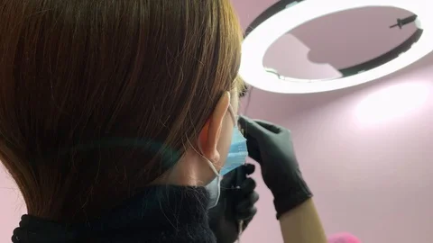 Master prepares tools for work. Cosmetology procedure. Applying red permanent  Stockbeeldmateriaal 119892535