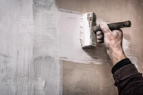 Master prime a putty wall before applying a decorative layer of plaster Stock Photos