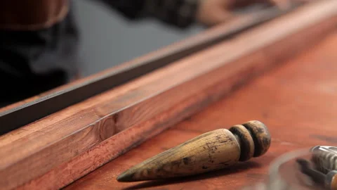 The master processes the edges on the leather strap with a special tool Stock Footage 86708191