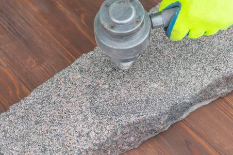 The master processes granite using a special tool. Close-up Foto stock