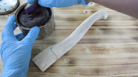 The master processes the wooden handle from the axe with wax. Stock Footage 156667373