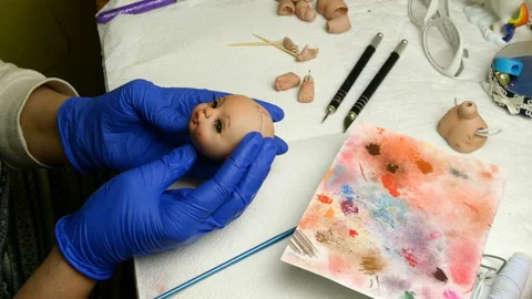 Master puppet examines produced to her dolls head. Stock Footage 128684788