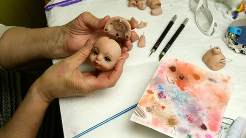 Master puppet examines produced to her dolls head. Stock Footage 128686066