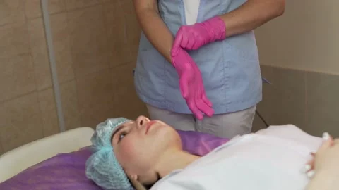 Master Puts on and Corrects Rubber Gloves in the Beauty Salon before the Facial  Stock Footage 163991033