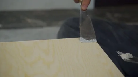 The master putties the nail-head on the table surface with light gray coating. Stock Footage 83531676