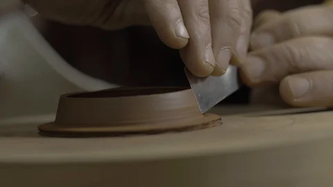 The master removes excess clay from the lid for the teapot from Yixing clay Stock Footage 119000302