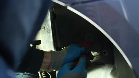 The master removes the plug under the wing and behind the wheel of the car with Stock Footage 320127892