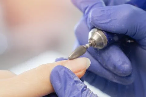 Master removes shellac gel from woman nails salon, manicurist use portable pen Stock Photos