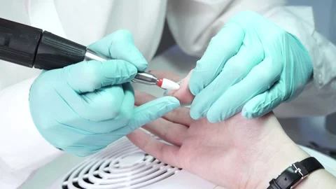 Master is removing the gel polish from the customer's nail with nail drill Stock Footage 194463835