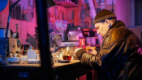 Master repairs electronic staff at own garage workshop with neon light Stock Footage 87677262