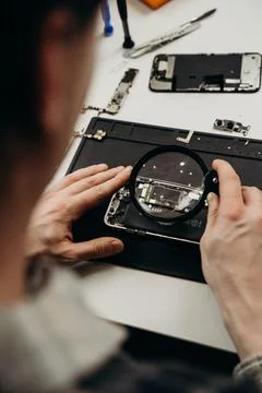The master repairs the equipment at the table on a black background Stock Photos