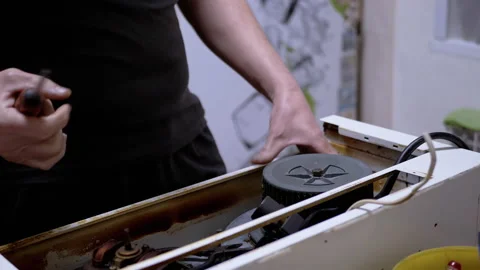 Master Repairs the Old Dirty, Rusty Kitchen Hood in the Kitchen. 4K. Close-up Stock Footage 229796727