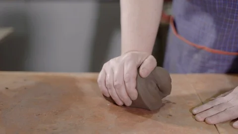 Master rolling out clay. Crop strong hands of talented potter wedging for Stock Footage 90160592