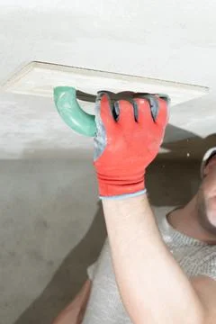 The master rubs the ceiling with a moisture-absorbing grater for lime plaster 스톡 사진