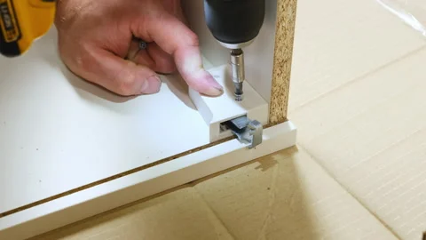 Master screws hinges for sliding part of cabinet on floor Stock Footage 304399928
