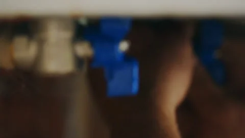 Master screws the opening and closing valve to the heating system Stock Footage 90896781
