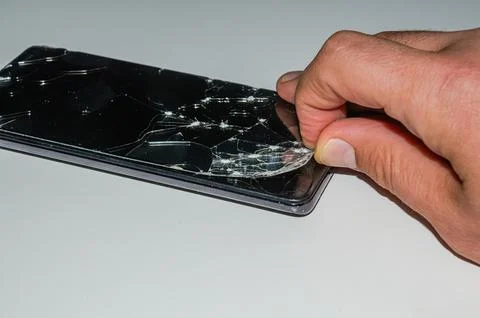 The master in the service center changes the broken glass of the screen in the s Stock Photos