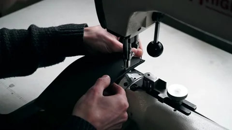 The master sews leather on a sewing machine, sewing of leather goods Stock Footage 151207765