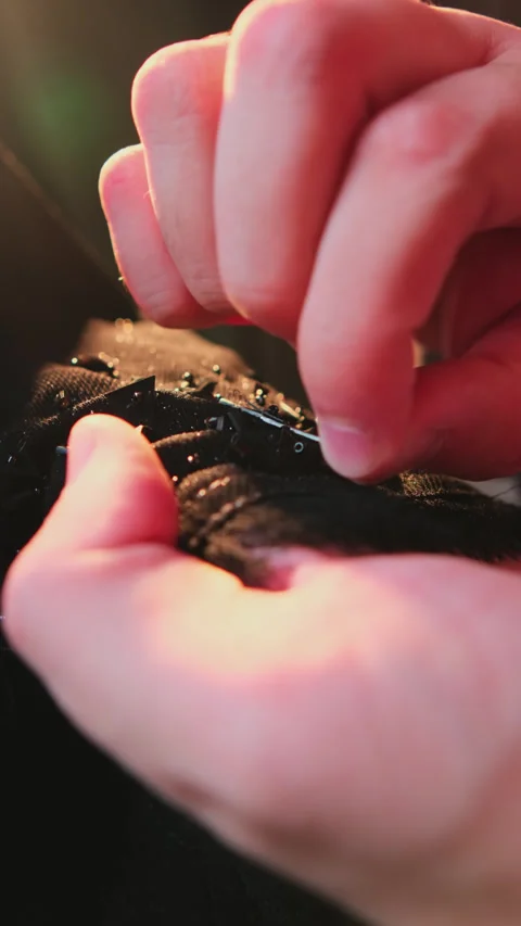 A master sews national Arab clothes abay with a needle and thread in his atelier Stock Footage 311682631