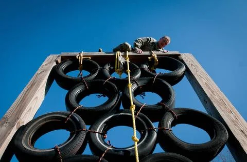 Master Sgt. Josh Devine climbs over a tire tower at Southern High School D... Fotos de archivo