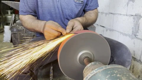 A master sharpening a metal knife, making it sharp Stock Footage 246475575
