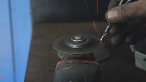 A master sharpens a drill using an emery disc Stock Footage 252529822
