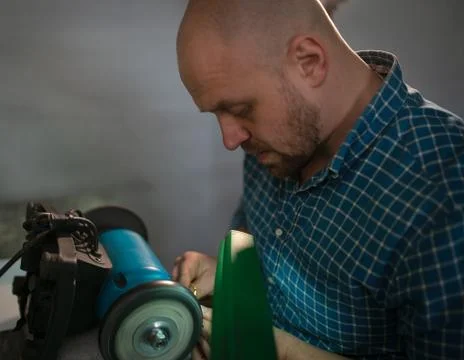 Master sharpens scissors on special equipment for sharpening tool Stock Photos